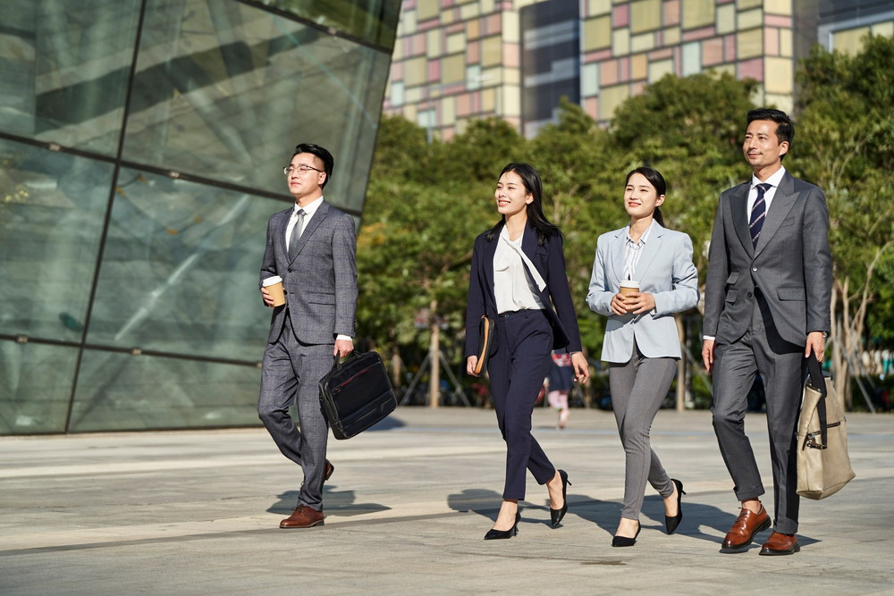 Group,Of,Four,Young,Asian,Business,People,Walking,Outdoors,On